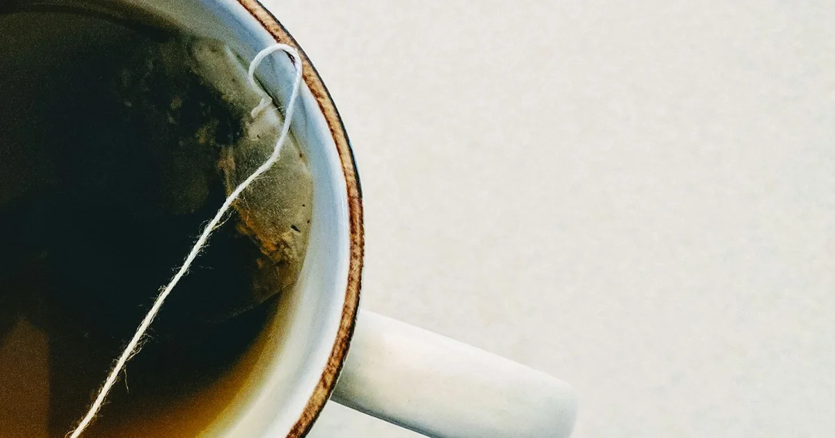 A mug of tea with the tea bag string draped over the rim, seen from above